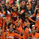 Cheerleaders taking a break to pose for a group picture during a Friday night football game