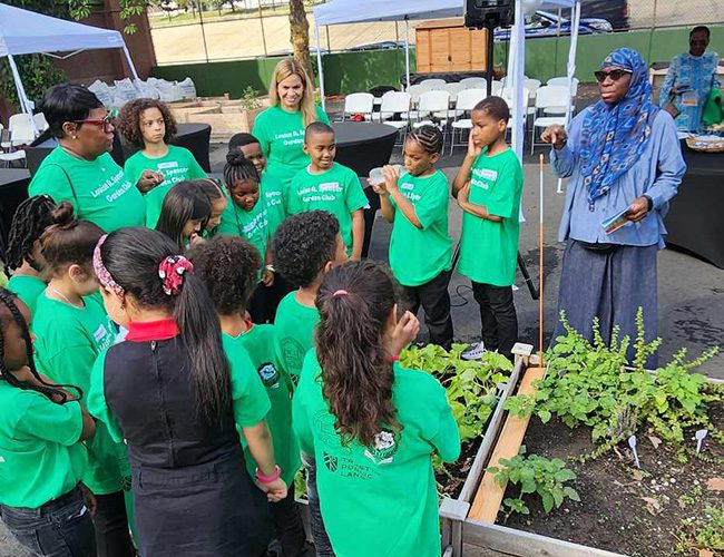 Dena Corbin, Newark Board Member Allison James-Frison, and students exploring garden beds